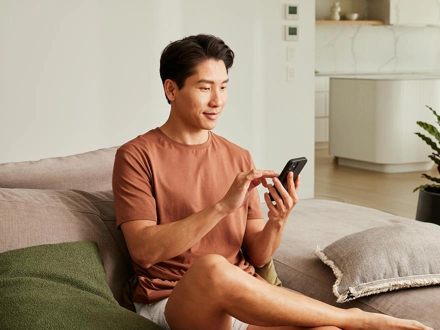 Man on a sofa looking at his phone