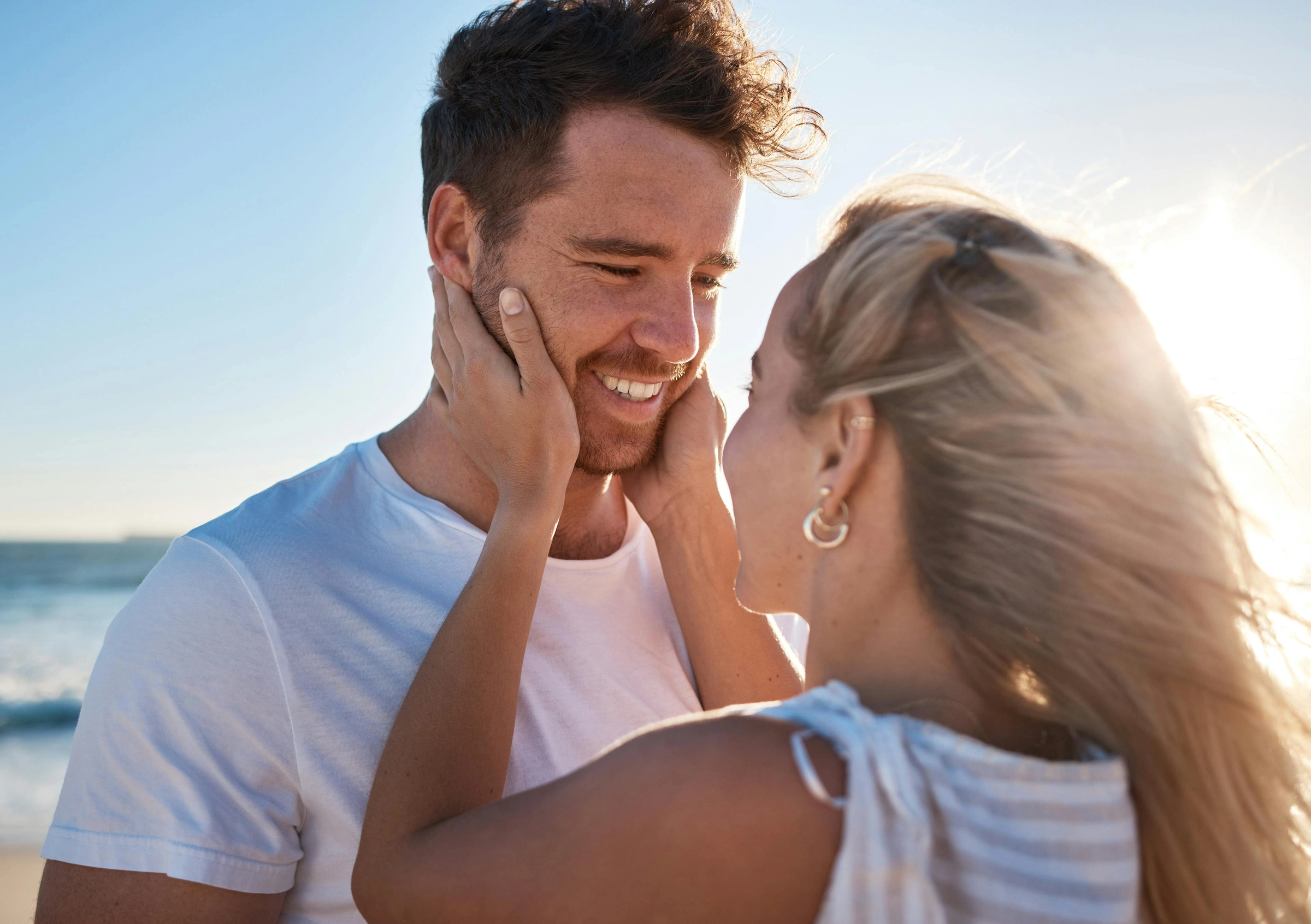 Woman lovingly embracing her partner at the beach
